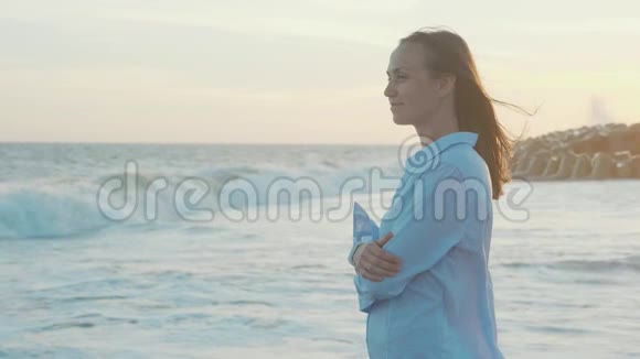 夕阳暖光中看海的年轻女子侧影视频的预览图