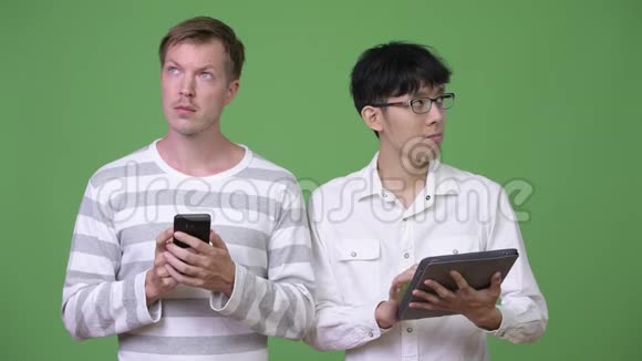 两位年轻的多民族商人使用手机和数字平板电脑来社交媒体概念视频的预览图