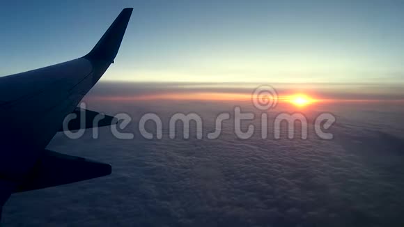 透过飞机的窗户在云层上日落视频的预览图