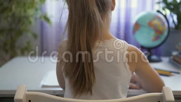 一个做作业的金发小女孩的后视图视频的预览图
