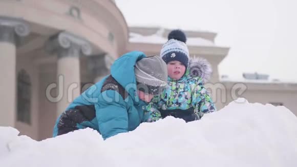 孩子们在雪山上玩耍扔雪和晴朗的霜天新鲜空气中的乐趣和游戏视频的预览图