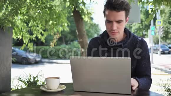 损失男人坐在咖啡馆露台上对笔记本电脑的成绩感到沮丧视频的预览图