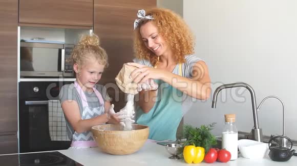 小女孩和她妈妈把面粉洒进碗里一边烤一边笑视频的预览图