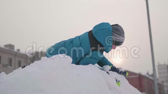 少年在雪山上玩耍从上往下看晴朗的霜天新鲜空气中的乐趣和游戏视频的预览图