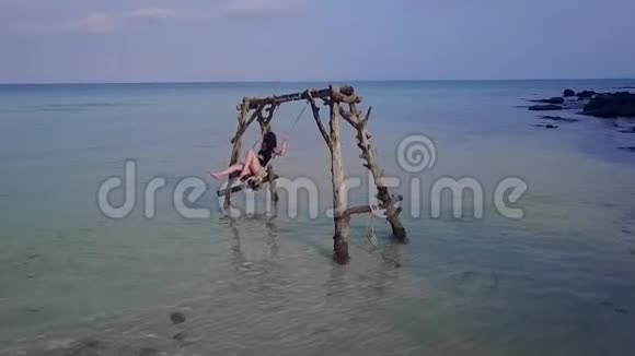 女孩在海中荡秋千水荡秋千失乐园无人居住的岛屿视频的预览图