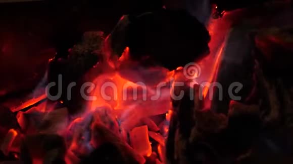 闪耀着鲜红的火煤燃烧着明亮的光芒篝火热柴火正烧红蓝火特写视频的预览图