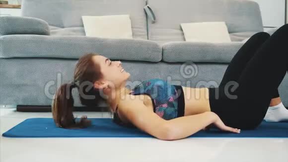 一个健康的女人在家里穿着运动服和训练做体育锻炼健康的生活方式视频的预览图