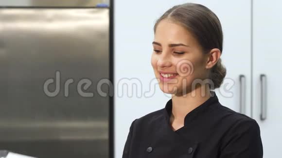 迷人的女面包师微笑着拿着棉花糖的蝴蝶结对着镜头视频的预览图
