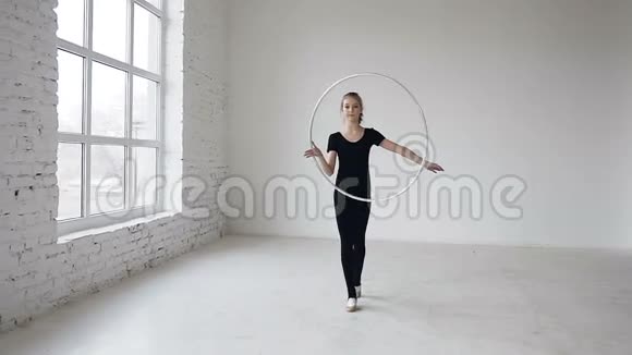 白人体操学校里一个年轻漂亮的快乐女孩在手上旋转着篮圈视频的预览图