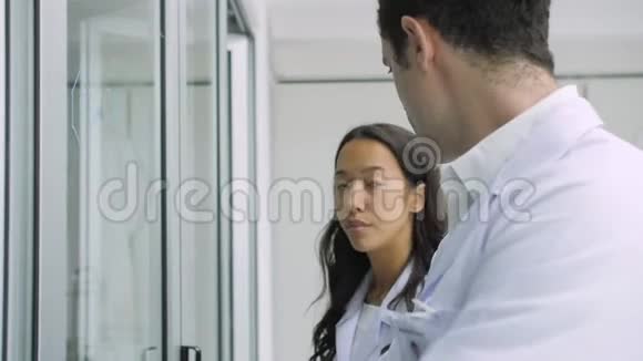 医学研究科学家在玻璃白板上写下科学公式视频的预览图