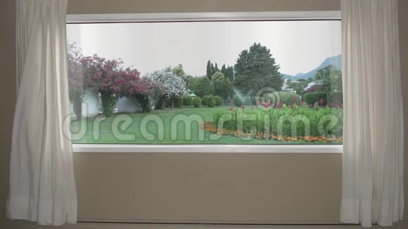 从窗户到美丽的花园有草坪鲜花和自动喷水系统背景板色度键视频的预览图