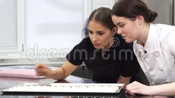 两个女糖果师在托盘上检查蛋糕视频的预览图