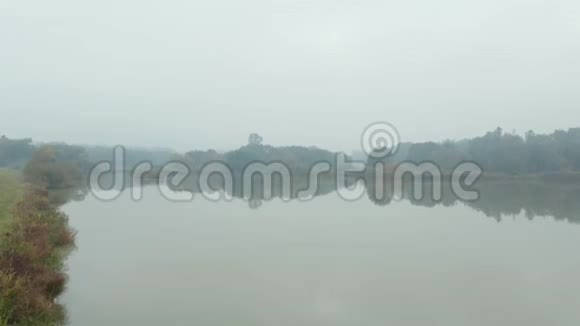 空中景色反射雾湖与空金属筒仓在一个草山视频的预览图