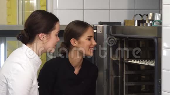 漂亮的女糖果师和她的助手在烤箱里检查内衣视频的预览图