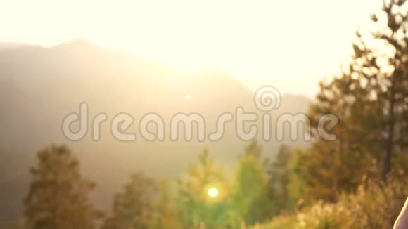 一个男人带着一个女孩在夕阳和群山的背景下朋友的手拉着拱门视频的预览图