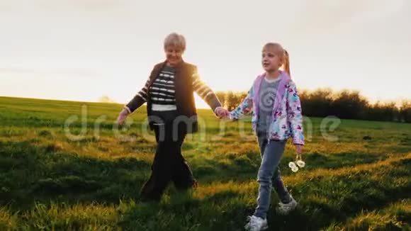 活跃的老年人祖母和大女儿6岁的女孩一起散步在风景如画的地方视频的预览图