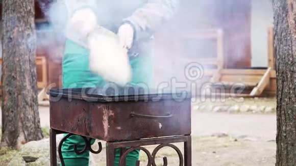 人在烤架上的煤块上挥舞着木板视频的预览图