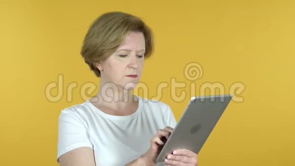 老女人浏览互联网使用平板电脑视频的预览图