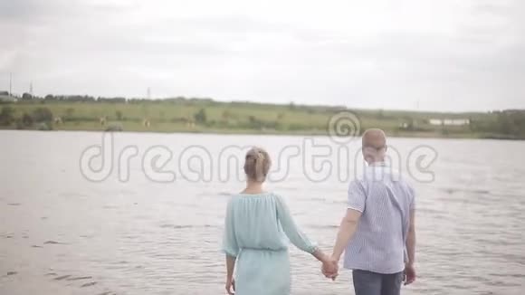 幸福的恋人站在河里欣赏风景视频的预览图