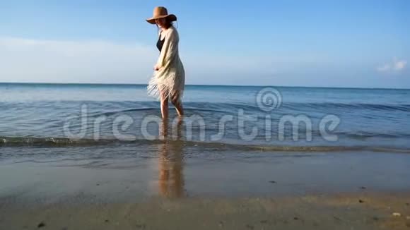 戴草帽的年轻女子在海边享受和跳舞视频的预览图