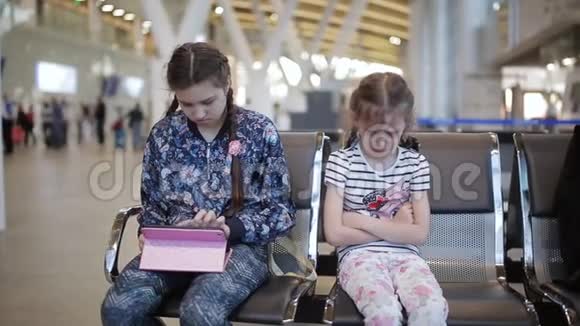 两个姐妹在机场小女孩因为药片而对她妹妹生气视频的预览图
