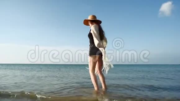 戴草帽的年轻女子在海边享受和跳舞视频的预览图
