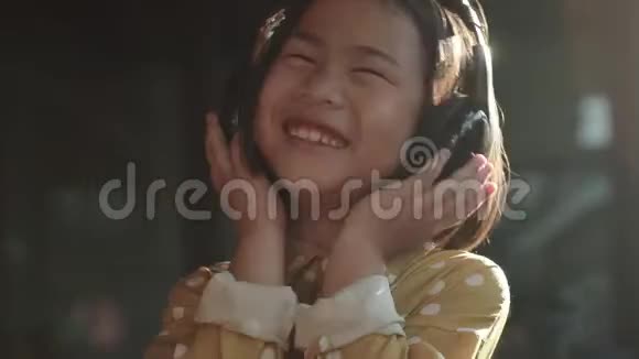 亚洲儿童在电话中听到音乐的肖像牙齿微笑快乐情感视频的预览图