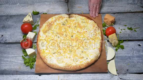 用滚刀切出的美味披萨框架厨师用专业刀切开木托盘上的披萨视频的预览图