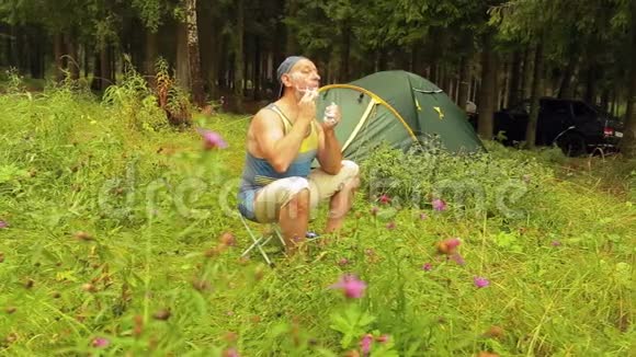 一个游客坐在帐篷附近刮脸视频的预览图