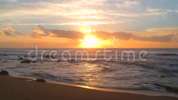 日落时在沙滩和大西洋上空拍摄水面上有倒影视频的预览图