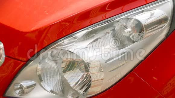 男人手在一辆红色的车里洗一盏前照灯视频的预览图
