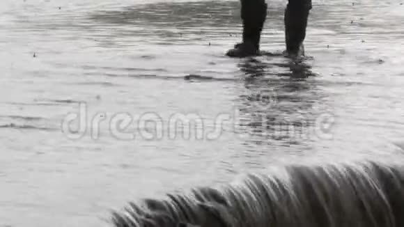 灾难村庄里的洪水肮脏的黑色河流沿着道路流动穿着黑色橡胶靴的人穿过视频的预览图