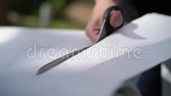 俄罗斯圣彼得堡2018年8月18日女性包装专家用剪刀切割乙烯基箔片或薄膜视频的预览图