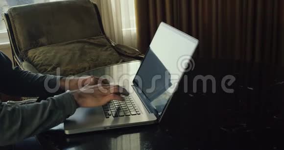 人在笔记本电脑键盘上打字自由职业者通过电子邮件向客户发送项目4k视频的预览图