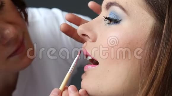 化妆师将唇彩涂于模特唇上全高清视频的预览图