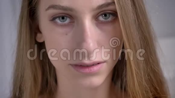 年轻漂亮女人的肖像触摸她的脸看着镜头迷人和自信视频的预览图