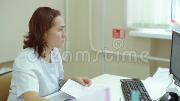 在电脑上工作的微笑女医生的正面景色视频的预览图