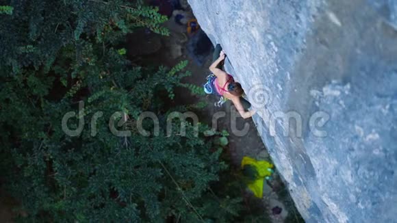 女人在艰难的运动路线上攀爬攀岩者在艰难的运动中视频的预览图