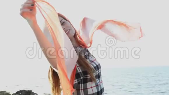 美丽的女人披着红色的披肩在风中飘扬视频的预览图