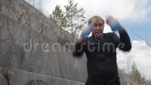 男运动员在大理石采石场用哑铃训练徒手格斗视频的预览图