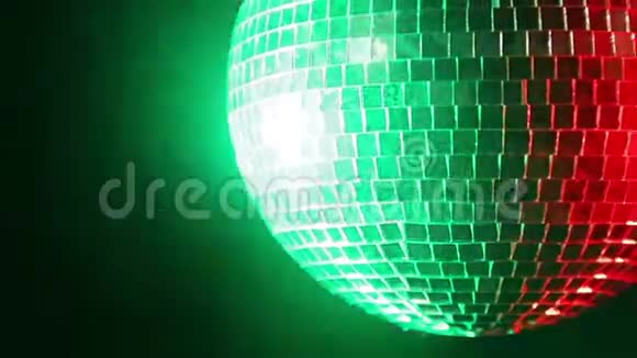 红色和绿色聚光灯下黑色背景上的镜面迪斯科球视频的预览图