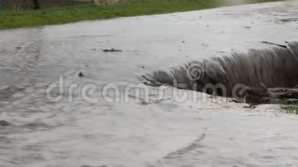 灾难村庄里的洪水肮脏的黑色河流沿着道路流动穿着黑色橡胶靴的人穿过视频的预览图