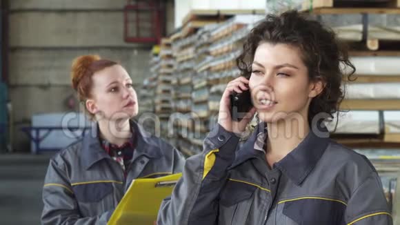 美丽幸福的女工厂工人在电话里交谈视频的预览图