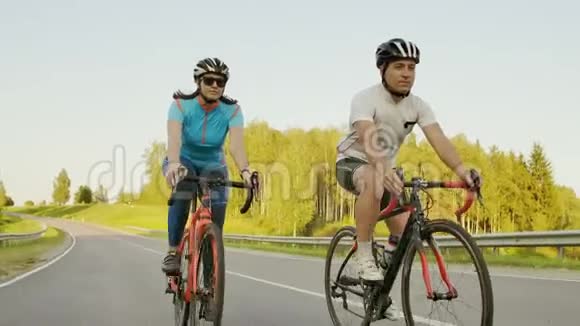 一个英俊的留胡子的职业男性自行车手和他的女朋友一起骑着他的赛车视频的预览图