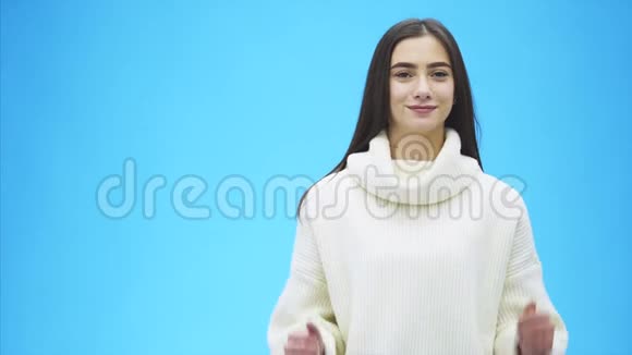 年轻女孩生意的肖像蓝色背景的高级女孩在这段时间里她穿着一件温暖的白色衣服视频的预览图