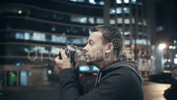 这位艺术摄影师在建筑师美丽的建筑背景下拍摄夜城视频的预览图