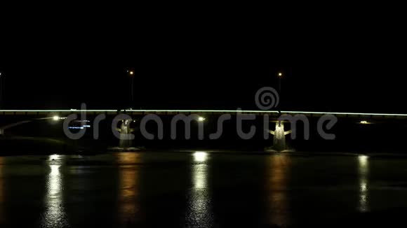 汽车在夜间照明的小桥上微弱的移动视频的预览图