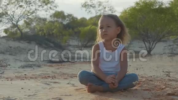 小女孩坐在沙漠里用一千码的目光思考着什么视频的预览图