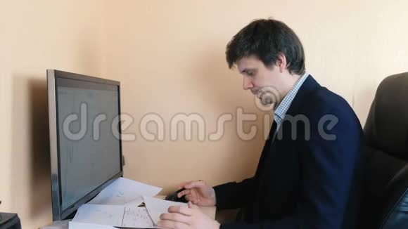 人在电脑上工作扫描纸上的图形视频的预览图