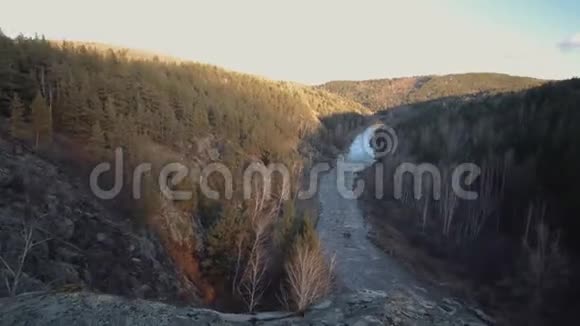 日落时从悬崖上看到山河在峡谷河和针叶林中太阳太阳的光芒视频的预览图